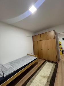 a bedroom with a bed and a wooden cabinet at Famely apartmen in Prizren
