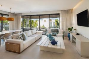 a living room with a white couch and a tv at Donoma Las Terrenas Resort & Villas, Autograph Collection in Las Terrenas