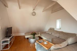 a living room with a couch and a tv at Ferienhaus Carpe diem in Bodman-Ludwigshafen