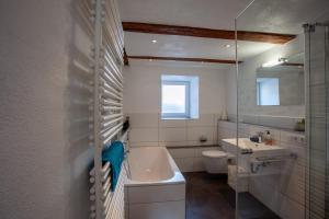 a bathroom with a sink and a tub and a toilet at Ferienhaus Carpe diem in Bodman-Ludwigshafen +24 photos