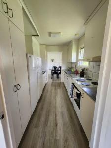 a kitchen with white cabinets and a wooden floor at Evita in Kosta