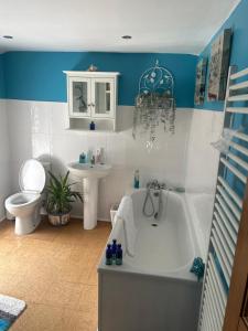 a bathroom with a tub and a toilet and a sink at Glan Morfa in Morfa Nefyn +11 photos