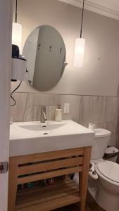 a bathroom with a sink and a mirror and a toilet at Private King Bed Room Near UPEI & Downtown Cozy Retreat Near Everything in Charlottetown +1 photo