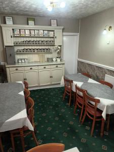 una sala da pranzo con due tavoli e una cucina di Strides Hotel a Blackpool