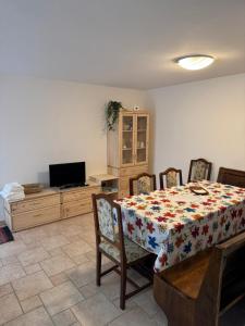 a dining room with a table and chairs and a television at Alloggio ai Campanari in Conco +7 photos