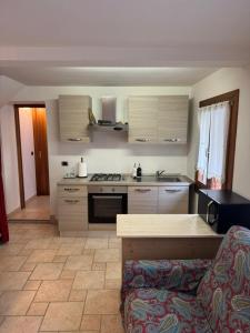 a kitchen with a stove and a couch in a room at Alloggio ai Campanari in Conco