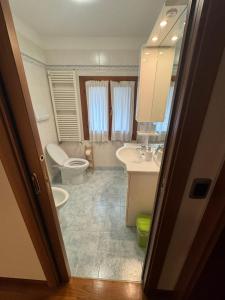 a bathroom with a toilet and a sink and a mirror at Alloggio ai Campanari in Conco