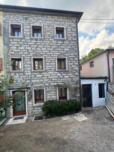 a large stone building with a lot of windows at Alloggio ai Campanari in Conco