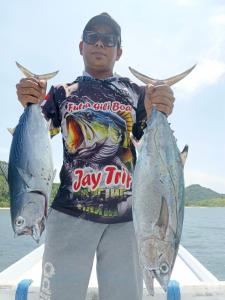 a man holding two fish in his hands at Jay Guest House Gili Gede in Sekotong