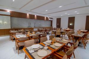 a restaurant with wooden tables and chairs and a large screen at SUNSET HOTEL in Nouakchott