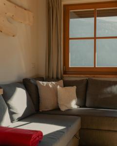 a couch in a living room with a window at Hofer Hof in Feldthurns