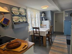 a kitchen with a table and a dining room at Lite hus ved sjøen in Evjen