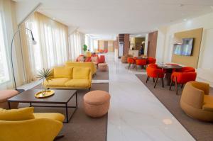 a lobby with yellow and orange furniture and tables and chairs at SUNSET HOTEL in Nouakchott