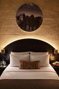 a bedroom with a bed with a painting of horses on the wall at Very Peri Cappadocia - The Lifestyle Luxury Design Hotel in Uçhisar +154 photos