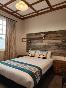 a bedroom with a large bed with a wooden headboard at Alexandra Hotel in Pirongia