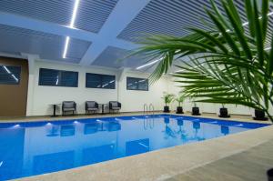 a swimming pool with a palm tree in a building at SUNSET HOTEL in Nouakchott