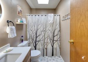 a bathroom with a shower curtain with trees on it at Lawrences Hideaway in Wilmington +11 photos