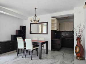 a dining room with a black table and white chairs at Apartment Pasha in Pržno