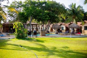a resort with a yard with chairs and huts at Orla Nautica in Barreirinhas