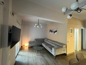 a living room with a large couch and a television at Luxury Serenity in Piraeus