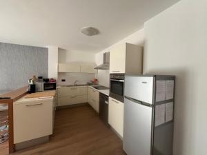 a kitchen with white cabinets and a refrigerator at Ca' Bertera in Ledro