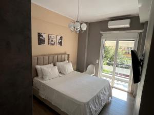 a bedroom with a white bed and a window at Luxury Serenity in Piraeus