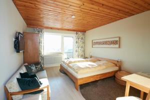 a bedroom with a large bed and a window at Pension KaraMia in Fichtelberg