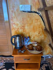 a table with a tea kettle on top of it at Giri Garden Sunset Glamping in Gitgit