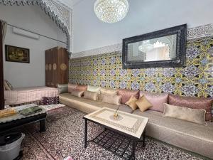 a living room with a couch and a table at Riad El abrar in Salé