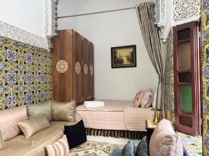 a living room with a couch and a bed at Riad El abrar in Salé