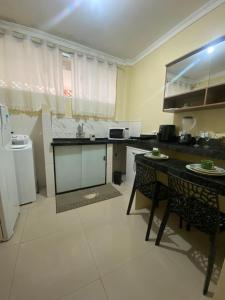 a kitchen with a table and a counter top at Kitnet linda 8A in Montes Claros