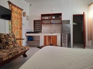 a living room with a bed and a kitchen at Susans cottages diani beach in Ukunda