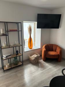 a living room with a orange chair and a vase at Appartement chez pépite in Namur