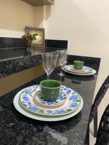 a table with two plates and two glasses on it at Kitnet linda 8A in Montes Claros