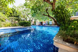 a blue swimming pool with trees in the background at Horizon Karon Beach Resort & Spa in Karon Beach
