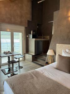 a bedroom with a bed and a table and a kitchen at Hôtel et SPA des sources du gros noyer in Malaucène +57 photos