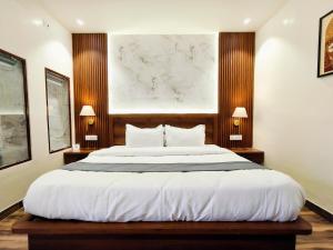a bedroom with a large white bed with two lamps at Paradise Boutique Stays in Solan
