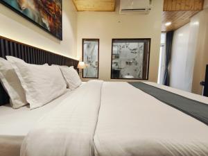 a large white bed in a room with two windows at Paradise Boutique Stays in Solan +39 photos
