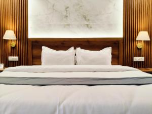 a bedroom with a large bed with white sheets and pillows at Paradise Boutique Stays in Solan