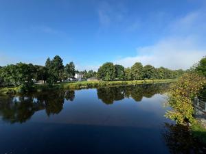 a river with trees reflecting in the water at Lodge 18 - Caer Beris Park - No Tradesmen in Builth Wells +8 photos