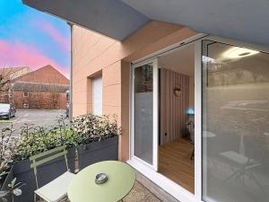 a balcony with a table and a glass door at Studio avec terrasse in Amiens