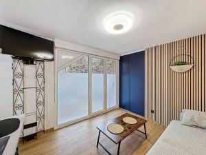 a living room with a couch and a table at Studio avec terrasse in Amiens
