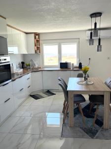 a kitchen with a table and a table and chairs at Apartman Stari Grad in Cazin