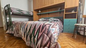 a bedroom with bunk beds and a bed with a blanket at Casa Angelo in Torri del Benaco
