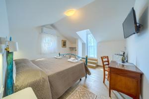 a bedroom with a bed and a table and a television at Villa Mirena in Kožino