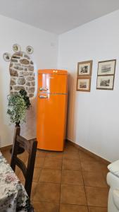 an orange refrigerator in the corner of a room at Casa Angelo in Torri del Benaco