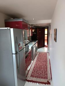 a kitchen with a refrigerator and a rug on the floor at بورتو السخنه الاهرامات in Banī Ghālib