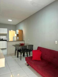 a living room with a red couch and a table at Dunas residence casa 04 in Santo Amaro