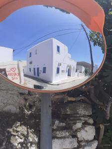 a mirror with a reflection of a white house at Takis House in Gavrio +3 photos