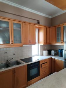 a kitchen with wooden cabinets and a sink at Takis House in Gavrio